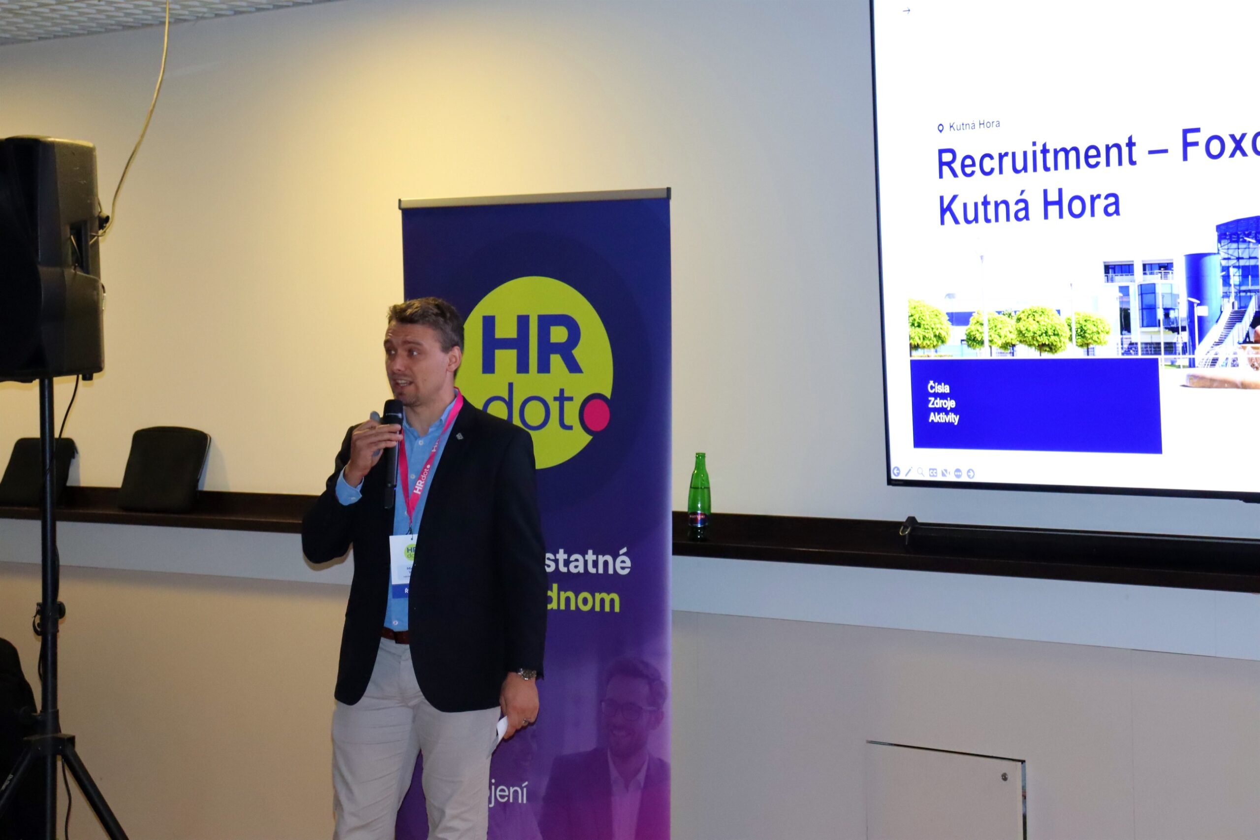 Michael Vávra s mikrofonem před titulním slidem Recruitment Foxconn Kutná Hora